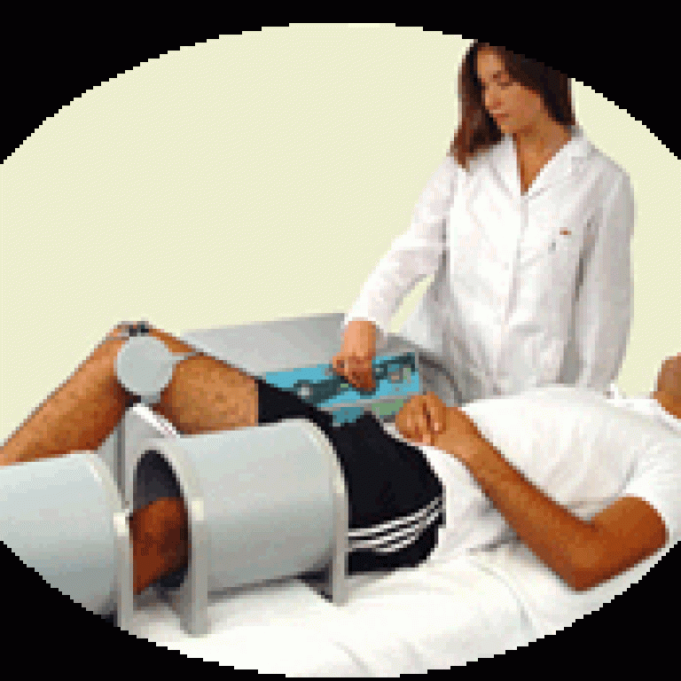 paciente acostado recibiendo tratamiento de magnetoterapia en una habitación con equipo medico